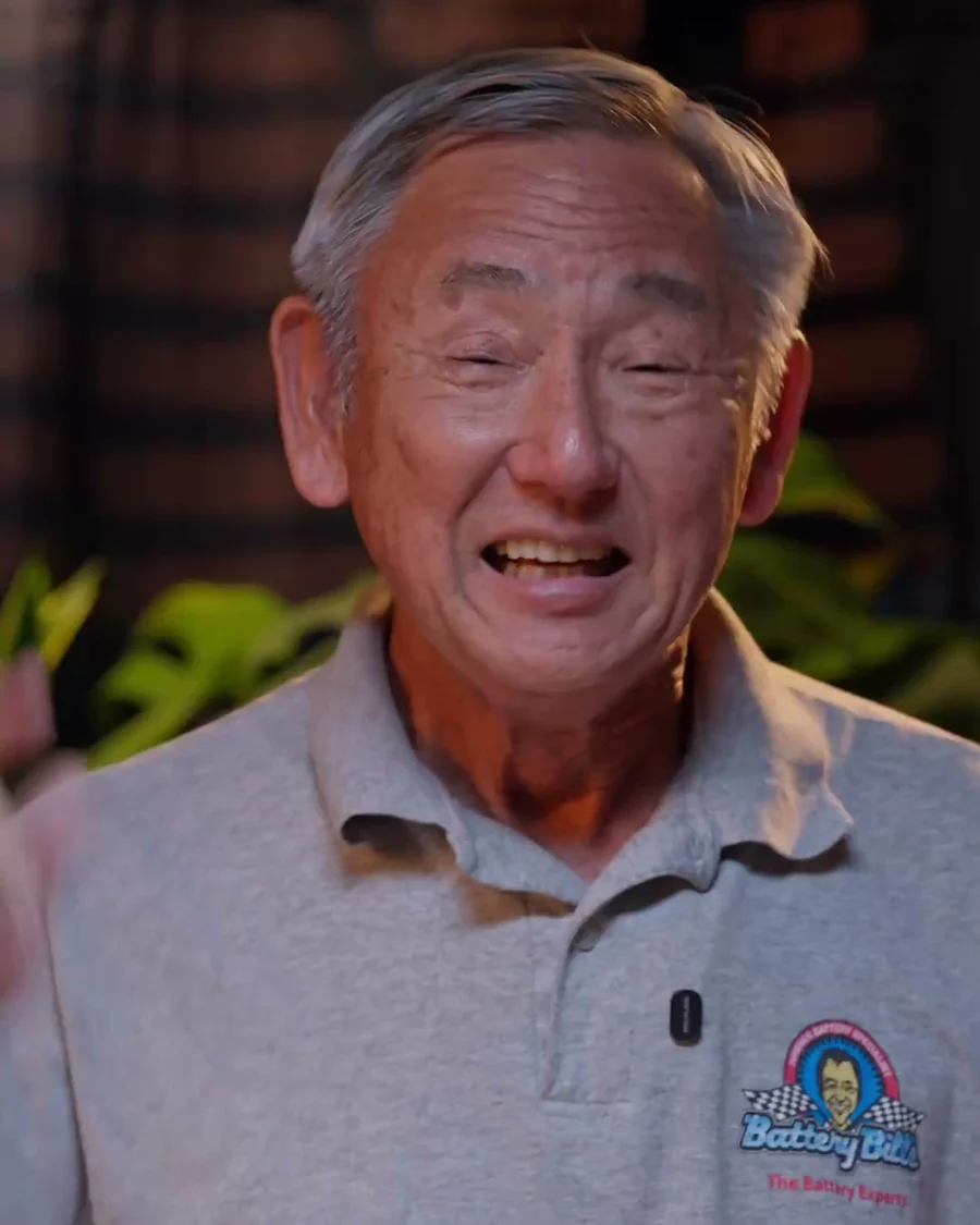 Bill Ogawa, owner of Battery Bill's, wearing a Battery Bill's polo shirt.